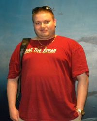 Stephen Box before weight loss, standing in a red t-shirt with arms at his sides