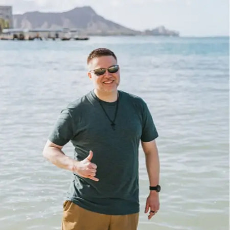 Photo of Stephen Box wearing a green shirt standing in the ocean